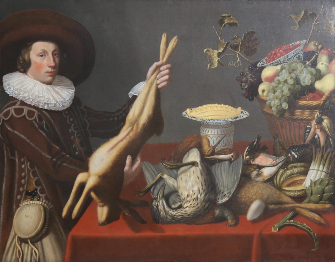 A Game Still Life with a Young Man Holding a Hare in front of a Table with other Victuals,Dutch, 1st half 17thc. by Monogrammist DV
